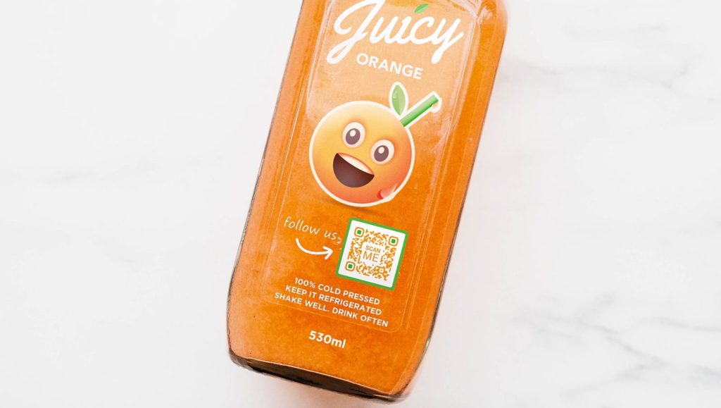 a glass bottle of orange juice with a qr code